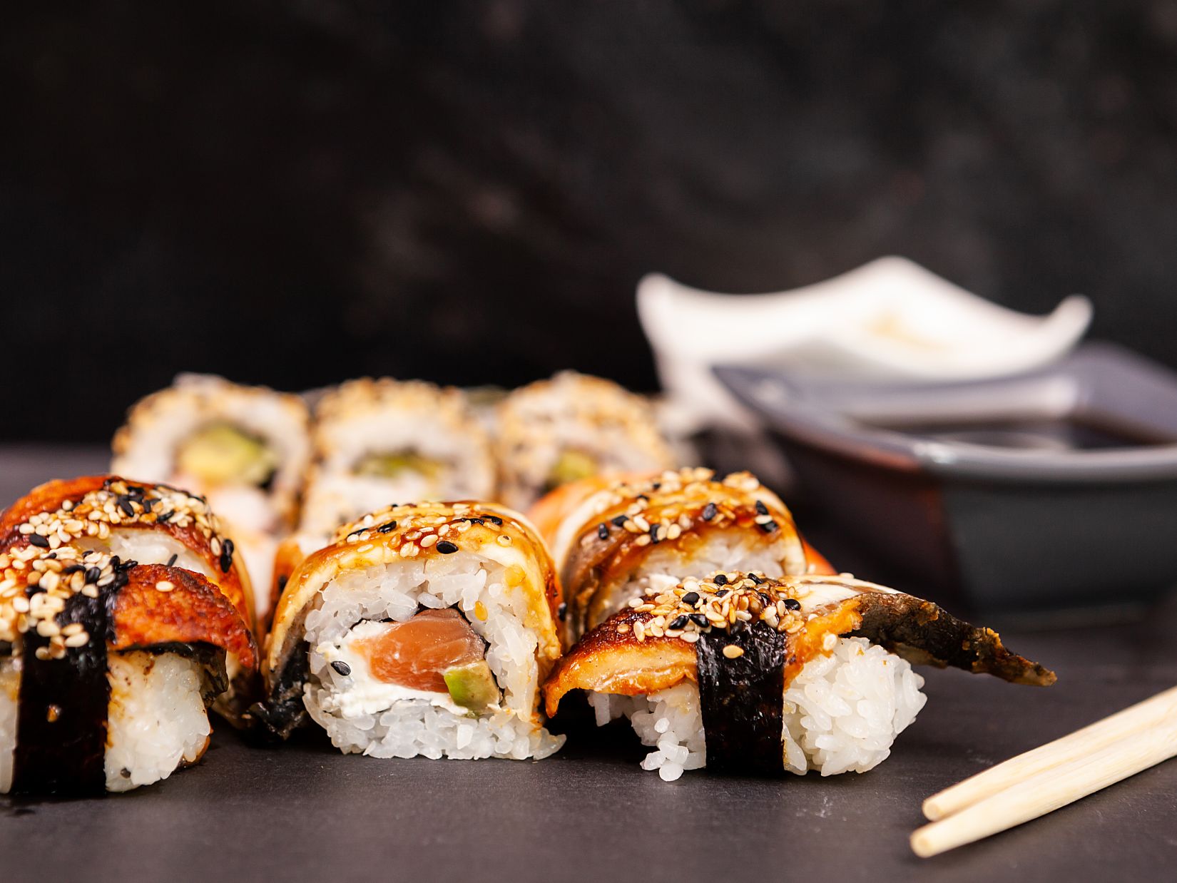 lot mix variety sushi rolls black stone background studio photo